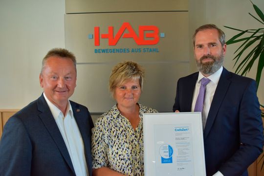 Creditreform-Prokurist Klaas Küther (r.) übergibt die inzwischen 10. „CrefoZert“-Urkunde an die HAB-Geschäftsführer Kathrin und Andreas Pörsch.(Bild:  HAB)
