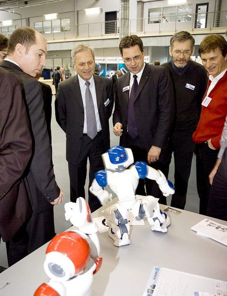 Die Geschäftsführer  Heinz-Dieter Schunk und Henrik A. Schunk (Bildmitte) bei der Begutachtung  des Spielzeugroboters NAO, der den Markt der Entwicklungsplattformen anführt. (Archiv: Vogel Business Media)