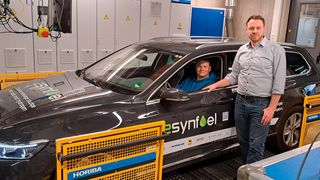 Im Auto sitzt Kfz-Techniker Florian Knoch, Kfz-Ingenieur Steffen Krajewski steht daneben: An der Hochschule Coburg führen sie die Tests auf dem Rollenprüfstand durch. (Bild: Anja Singer/ Hochschule Coburg)