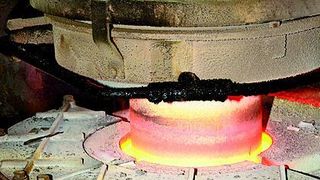 Bild 1: Im Feeder oberhalb der IS-Maschine werden die heißen Glastropfen mit gekühlten Messern abgetrennt. Diese werden von Servomotoren angetrieben, die bei Umgebungstemperaturen von 90 bis 100 °C zuverlässig arbeiten.  Bild: SEW-Eurodrive (Archiv: Vogel Business Media)
