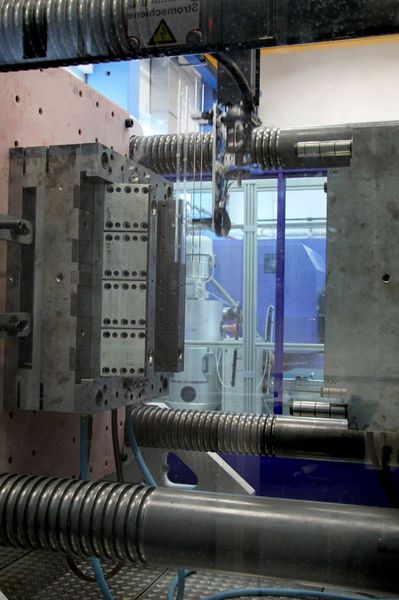 Das Entnahmesystem auf der Macropower im Einsatz: Entnommen wird soeben ein Lichtleiter aus dem geöffneten Spritzgießwerkzeug. (Wittmann Battenfeld)