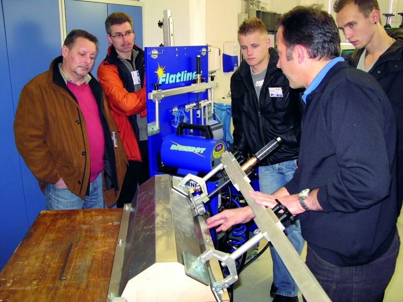 Franz Schnitzhofer (re.) führt den Workshop-Teilnehmern das Karosserie-Ausbeulsystem „Flatliner“ vor.  (Foto: Dominsky)