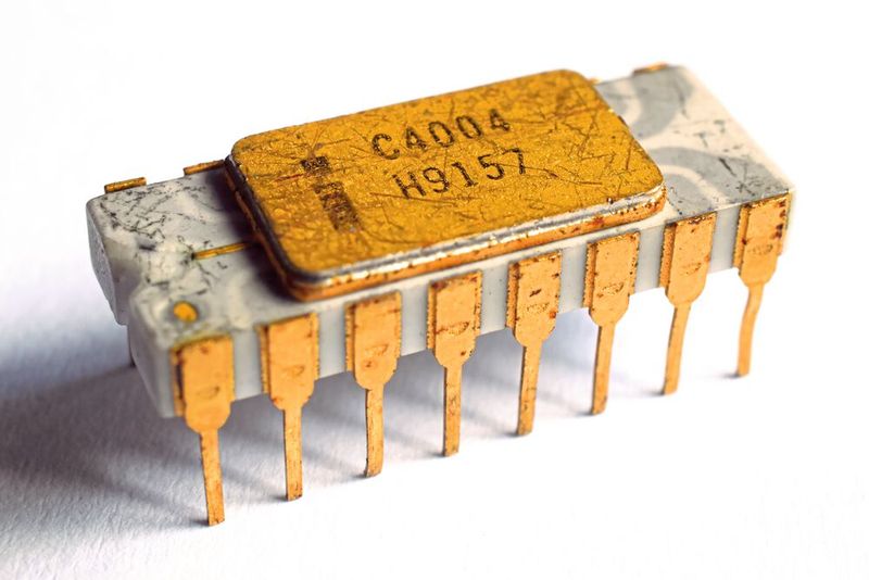 1971 – der erste Mikroprozessor: Der erste Mikroprozessor der Welt, der 4004, kam im März 1971 auf den Markt und markiert den Beginn von Intels Aufstieg in der Prozessorindustrie. Das Projekt MCS-4 – eine Auftragsarbeit für den japanischen Hersteller Busicom für vier Chips (Programmspeicher, Datenspeicher, Schnittstellen, CPU) – wäre allerdings fast gescheitert, weil die Ressourcen für diesen „Crash-Job“ fehlten. Denn die 1968 gegründete Firma Intel entwickelte mit Hochdruck Speicherchips.  Dass der „Job“ nicht misslang, ist vor allem dem jungen Ingenieur Frederico Faggin und seinem Einsatz von 80 Wochenstunden zu verdanken, der von Fairchild abgeworben wurde. Ende 1970 war das Chipdesign abgeschlossen. Faggin platzierte im Layout seine Initialen, ein kleines „F.F.“, das in jeden hergestellten 4004 geätzt wurde. Busicom besaß zuerst die Exklusivrechte am Design, veräußerte diese aber für einen Preisnachlass. So begann Intel im November 1971 mit der Werbung für den 4004: „Wir kündigen eine neue Ära der integrierten Elektronik an.“ Das hat sich bewahrheitet. (Bild: Ein Prozessor Intel C4004 mit Leiterbahne / Thomas Nguyen / CC BY-SA 4.0)