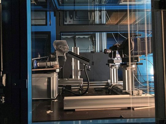 Druckluft durch Schläuche bis zum "Mund": Zwei Kameras können exakt erfassen, wie sich Tröpfchen durch Atemereignissen wie Husten in der Luft verbreiten. (Bild:  Empa)