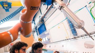 José Navarro, IDPSA, und José Saenz vom Fraunhofer IFF prüfen, wie VALERI das Dichtmittel auf ein Flugzeugbauteil aufgebracht hat. (Bild: Kuka)