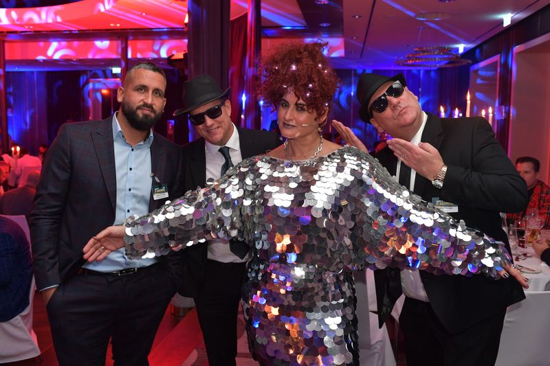 Blues Brothers Oliver Gorges, ITscope, Stefan Knerrich, APC, und Oktay Cayiroglu, NortonLifeLock, treffen auf Future Girl 2051. (Hannes Magerstaedt)