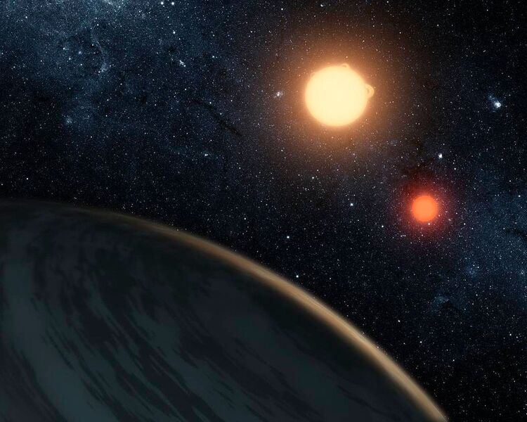 Kepler-16b ist der erste bekannte Planet, von dem wir wissen, dass er zwei Sterne umkreist - ein so genannter zirkumbinärer Planet. 

Seine beiden Sterne verdunkeln sich regelmäßig gegenseitig von der Erde aus gesehen und Kepler-16b verdunkelt ebenfalls im Transit seine Sterne. Die Daten zu diesen planetarischen Transiten erlaubten es, die Größe, Dichte und Masse des Planeten extrem gut zu bestimmen. Da die Umlaufbahnen der Sterne und des Planeten in einem gewissen Grad aufeinander ausgerichtet sind, gehen die Wissenschaftler davon aus, dass der Planet innerhalb der gleichen Gebiet gebildet wurde, in der sich die Sterne gebildet haben, statt später von den beiden Sternen eingefangen worden zu sein. (NASA/JPL-Caltech/T. Pyle)