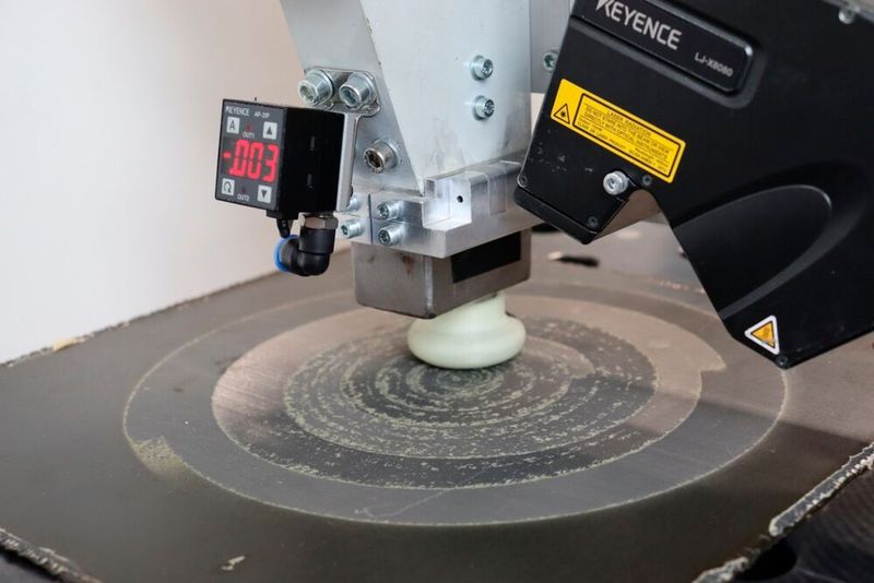 In Stade wurde auch eine per Roboter geführte Vakuumsaugstrahl-Düse für die saubere Oberflächenvorbehandlung von Composite-Teilen entwickelt. Hier sieht man sie beim sogenannten Schäften und Aktivieren eines mit Carbonfasern verstärkten Kunststoffteils (CFK). (Bild: Fraunhofer IFAM)