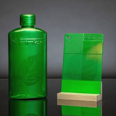 Gelaserte Flasche und Kunststoffplättchen mit hologrammähnlicher Markierung – erzeugt mit dem neuen Laseradditiv von Finke Colors in transparentem Polymer, ohne Veränderung der Oberfläche. (Bild: Finke Colors)