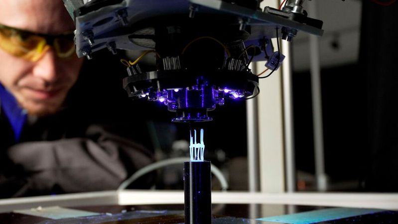Bei der neuentwickelten 3D-Druck-Technologie wird das photoreaktive Harz aus dem Druckkopf durch eine Düse gedrückt und unter Bestrahlung mit UV-Licht gehärtet. Da der Kunststoff schon in flüssiger Form vorliegt, muss er nicht mehr wie beim FFF-Verfahren energieintensiv geschmolzen werden.