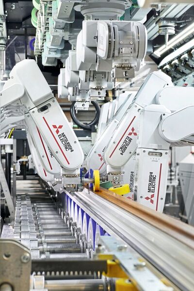 Jeder Roboter entnimmt seine für das jeweilige Profilsegment benötigte Rolle aus einem der insgesamt drei umlaufenden Kettenmagazine und begibt sich in die zugewiesene Andruckposition. (Mitsubishi Electric Europe B.V.)