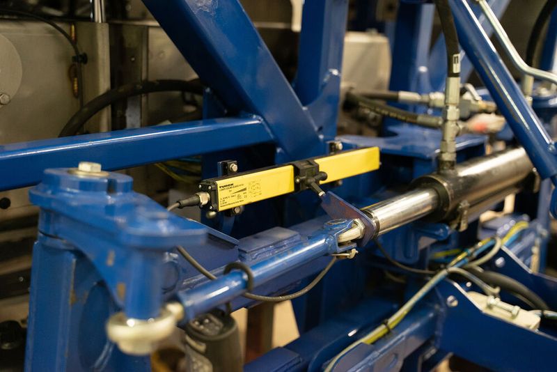 Dank robuster Ausführung und Schutzart IP67 kann der induktive Linearwegsensor Li500-Q25 auch außen, oberhalb der Vorderachse, montiert werden, um die Kolbenposition des Lenkzylinders zu messen. (Bild: Turck)