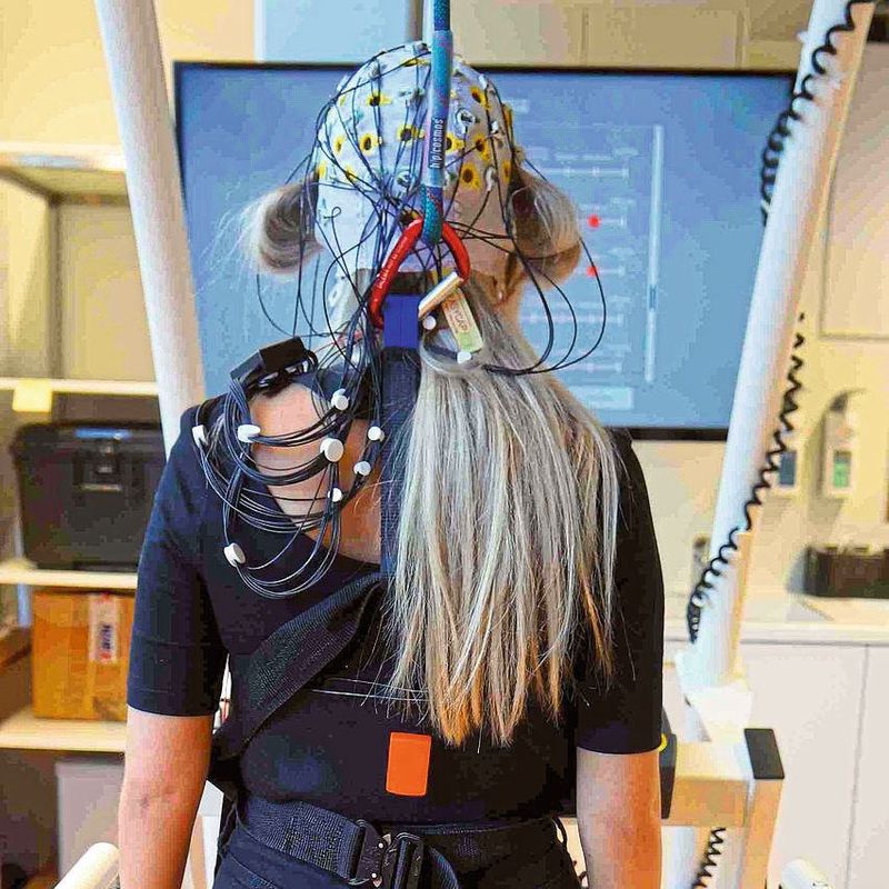 Im Brain-Imaging-Lab der Universität Ulm geht eine Probandin mit EEG-Haube auf dem Laufband.