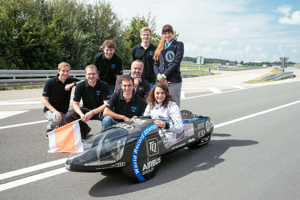 Angetrieben von Robodrive-Technologie: Das stolze TU-fast-Eco-Team mit der Prüferin von Guinness World Records (oben rechts), Manfred Schedl von der TQ-Group (Mitte) und dem E-Fahrzeug „eLi14“. (© Graeme Fordham/TQ-Group)