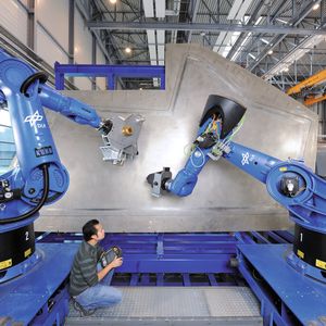 Grofi: effizientes Tapelaying und Fiberplacement mit CNC-Robotern. Sie arbeiten den Ablegeplan eines Teils gemeinsam ab oder bearbeiten mehrere Werkstücke parallel. Die Roboter werden vom Leitrechner mit Programmen versorgt, auch der Aufgabenstart kommt aus der Warte.