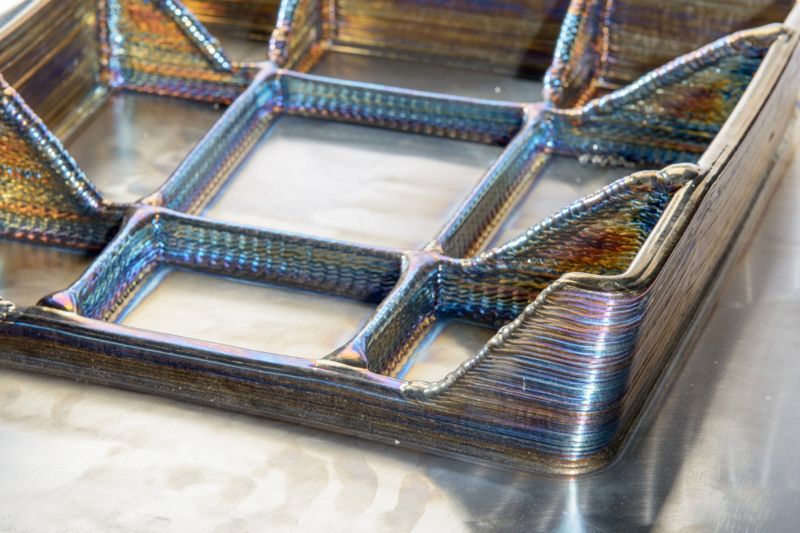 Der additive Fertigungsprozess basiert auf dem Prinzip des Lichtbogenschweißens. Durch das Auftragen des flüssigen Drahtmaterials Schicht für Schicht ermöglicht WAAM den Aufbau komplexer Metallteile praktisch „von unten nach oben“. (Bild: EWM)