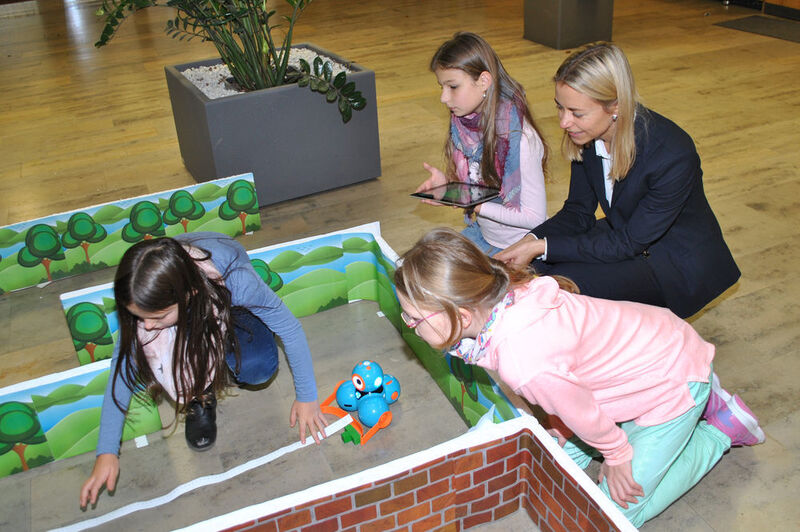 Schüler der Grundschule Heusweiler erproben eine der kleinen Lernwelten und messen Abstände, um einen Mini-Roboter zu programmieren.  (Ehrlich)