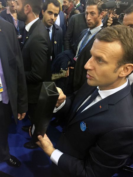 Frankreichs Päsident Emmanuel Macron bei der UN-Klimakonferenz 2017 in Bonn mit dem Muster eines Trägers aus kohlefaserverstärktem Granit.  (Stephan Savarese / Techno Carbon Technologies France)