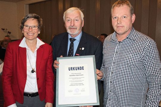 Zum Ehrenobermeister ernannt: Anja Bauer (stellvertretende Obermeisterin) und Günther Brodersen (Obermeister; re.) bei der Auszeichnung von Günther Görrissen.(Bild:  Kfz-Innung Flensburg Stadt und Land)