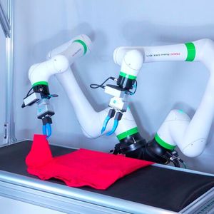 Mithilfe von Bewegungen, die durch imitatives Lernen in Echtzeit generiert werden, falten zwei CRX-Roboter selbstständig T-Shirts, während sie das Objekt mithilfe von Kameras visuell erkennen.(Bild:  Fanuc)
