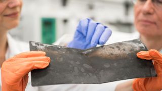 Prof. Jörg Acker und die wissenschaftliche Mitarbeiterin Jana Ducke untersuchen eine Kathodenfolie, die aus einer Lithium-Ionen-Batterie eines Elektroautos nach dessen Demontage entnommen wurde. (BTU Cottbus-Senftenberg)