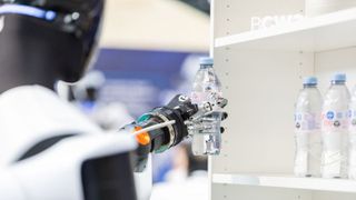 A humanoid robot takes a beverage from the shelf and places it on the counter. The demonstration at Bosch Connected World 2026 showcased key capabilities of humanoid systems in a specific handling process. (Image:Image: Schunk SE & Co. KG)