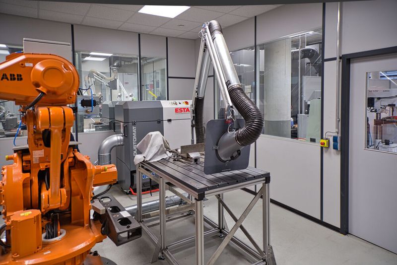 In der zweiten Kabine in München ist ein ABB-Roboter zu Hause, auf dem unterschiedliche Anwendungen gefahren werden können. Die Arbeit des Roboters begleitet ein Dustomat 4-24 ATEX (zur Verwendung in explosionsgefährdeten Bereichen) mit zwei Absaugarmen, der für Zone 22 zertifiziert ist. (Esta)