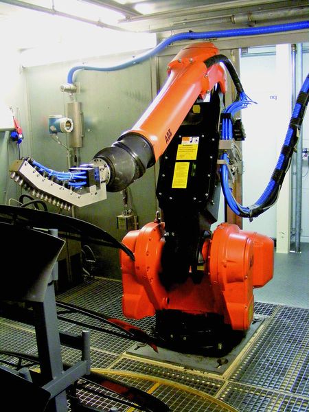 Bild 2: CO2-Schneestrahlkabine mit Roboter, der mit drei einzeln steuerbaren Düsenstöcken (Arrays) ausgerüstet ist. Die Versorgung mit Druckluft und flüssigem CO2 geht durch den Roboterarm hindurch. Bild: ACP (Archiv: Vogel Business Media)