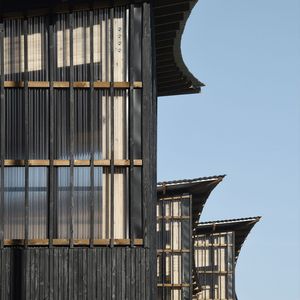 Die Fassaden bestehen aus verdunkelten Holzlatten, als ob sie in den Schatten des Vordachs eingetaucht wären. (Bild:  Guillaume Amat)