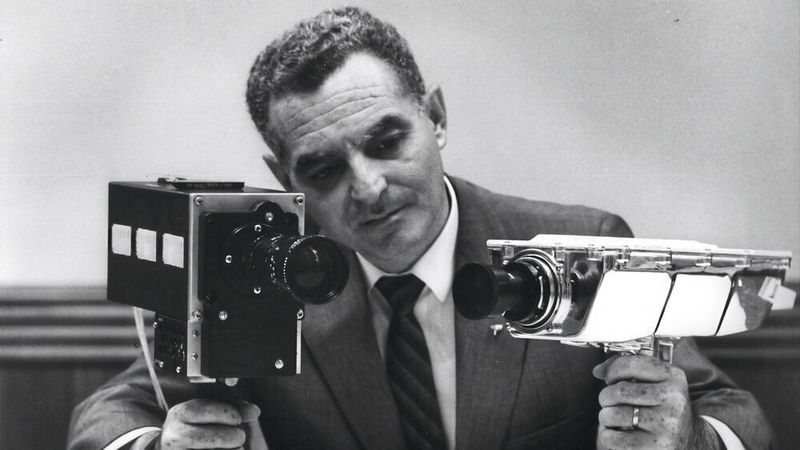 Stan Lebar, Programmleiter bei Westinghouse, mit den Apollo-TV-Kameras. Rechts die monochrome Lunar Surface Camera, die bei Apollo 11 Armstrongs erste Schritte auf dem Mond einfing – ihr einziger und letzter Einsatz. Links die Farb-Nachfolgekamera, die ab Apollo 10 zum Standard wurde.(Bild:   / CC0)