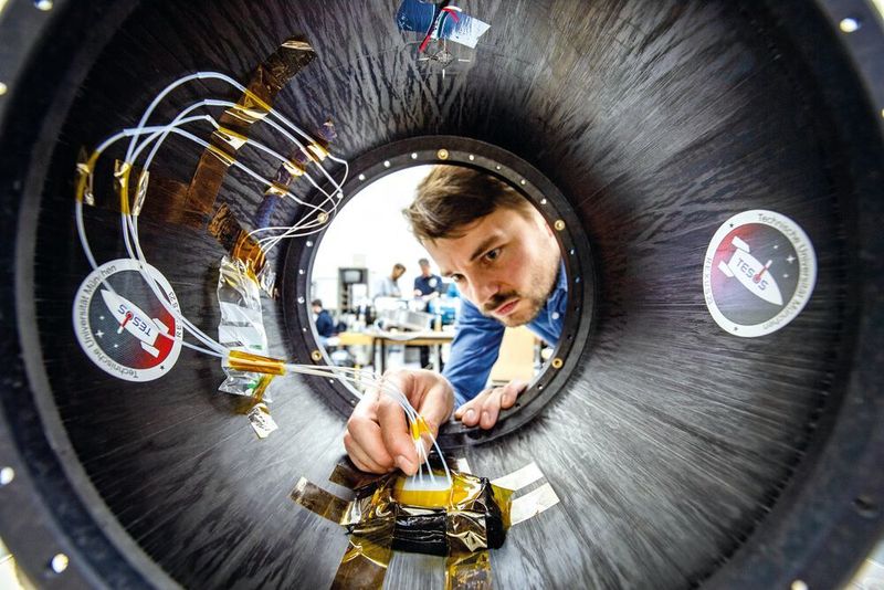 Ralf Engelhardt kontrolliert die faseroptischen Sensoren des Raketenmoduls.  (Andreas Heddergott / TU Muenchen)