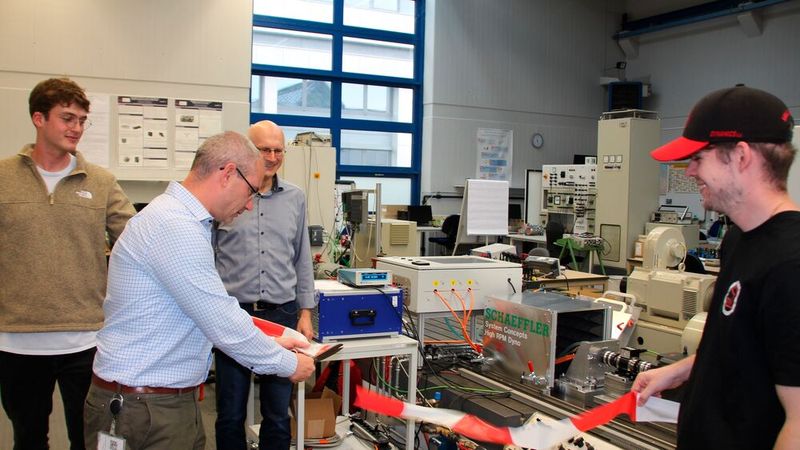 Simon Baensch, Head of System Concepts bei Schaeffler, eröffnet mit dem symbolischen Durchschneiden des Bands den neuen Hochdrehzahl-Prüfstand.(Bild:  Carla Sure/OTH Regensburg)