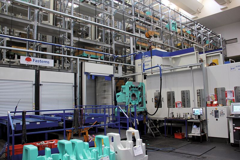 Ein Lagersystem mit 45 m Länge und über 10 m Höhe zur Zwischenlagerung von Roh- und Fertigteilen versorgt die vier Bearbeitungszentren des flexiblen Fertigungssystems. (Bild: Kuttkat)
