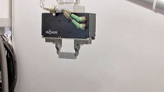 Bild 1: Hat der Elektrogreifer Werkstücke auf der Schiene zwischenplatziert, packt er die ganze Reihe und setzt sie in eine vorbereitete Versandpalette. (Bild: Röhm)