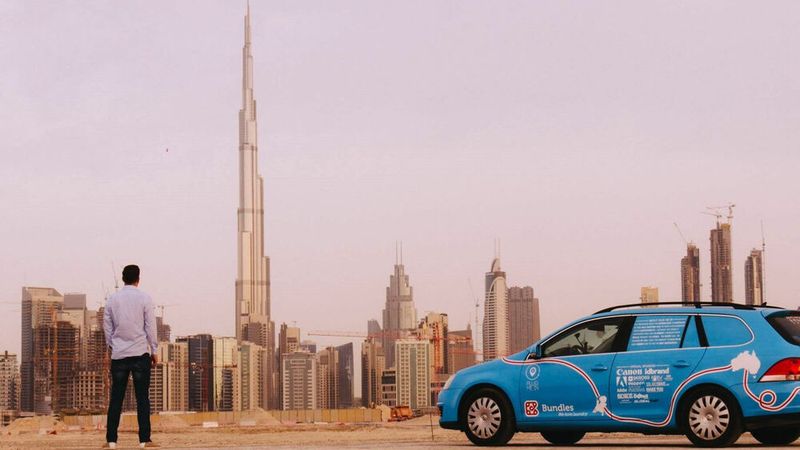 Große Bauwerke und kleines Auto: Wiebe Wakker mit seinem Elektro-Golf in Dubai. (Bild: Wakker)
