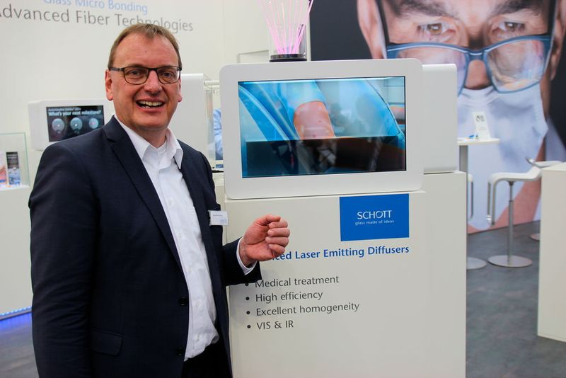 Jörg Warrelmann, Sales Director Europe der Medical Division im Geschäftsbereich Lightning and Imging der Schott AG, zeigt auf der Compamed 2018 neue Glasfaserlösungen für Laserapplikationen – darunter auch Puravis. Die umweltfreundliche optische Glasfaser, die unter anderem im Medical-Bereich zum Einsatz kommt, bietet dank ihrer reinen Rohstoffe natürliche Farbwiedergabe und hohe Langzeitstabilität. Im Sommer wurde dieses Produkt mit dem German Innovation Award des Rats für Formgebung ausgezeichnet.  (Reinhardt / Devicemed)