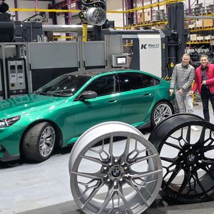 Im Vergleich zur herkömmlichen Produktion eines Pkw-Leichtmetallrads verringert sich der Energiebedarf bei dem vom Unternehmen Entec-Stracon entwickelten Herstellungsverfahren um die Hälfte, der Rohmaterialeinsatz um ein Viertel. Geschäftsführer Ralf Bux (rechts) und Mike Seidel, der Projektleiter Radentwicklung der BMW Group, deuten auf die bereits im Fahrzeug eingebaute Rad-Innovation. Die Deutsche Bundesstiftung Umwelt (DBU) hat das Projekt gefördert.(Bild:   Entec-Stracon)