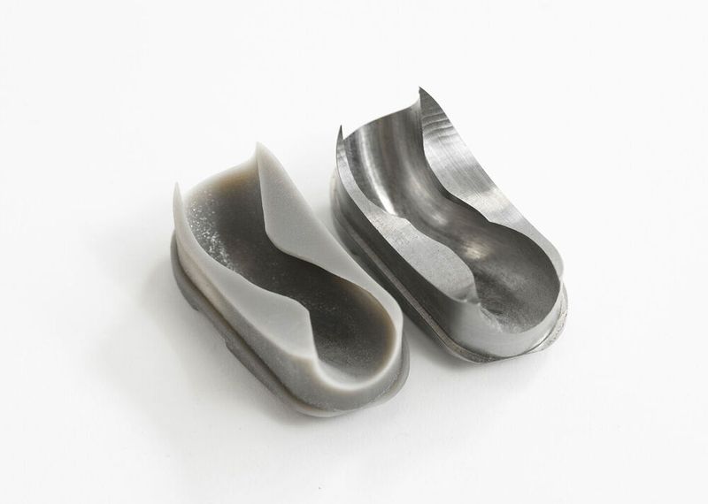 Auf dem 3D-Drucker hergestellte Einzelumlenkung (links) und das nach Modifizierung und Freigabe aus Stahl gefertigte Teil (rechts). Charakteristisch für die Einzelumlenkung sind die komplexen Kurven und Konturen, welche berechnet, konstruiert und gefertigt werden müssen. (Bild: joshuarzepka.com/Kamerer)