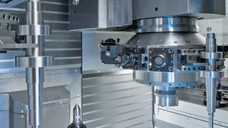 Bild 1: Über Greifer in den beiden Revolvern wird die Vertikaldrehmaschine Be- und Entladen. Die Werkstückzuführung erfolgt über die seitlichen Automationsbänder. (Bild: Emag)