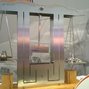 Am Hannover-Messe-Stand der Industrievereinigung Massivumformung: Es muss viel zusätzliches Gewicht auf die rechte Seite der Waage gelegt werden – dies entspricht der Gewichtsersparnis des optimierten massivumgeformten Bauteils gegenüber dem ursprünglichen massivumgeformten Bauteil (links).
