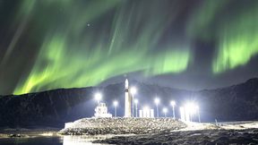 A Spectrum vehicle on its illuminated launch pad at Andøya Spaceport beneath sweeping curtains of northern lights. (Source: Isar Aerospace/ESA Standard Licence)