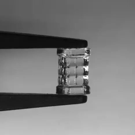 Researchers developed a new 3D printing method called blurred tomography that can rapidly produce microlenses with commercial-level optical quality. They used the technique to print a microlens array, which is shown being held by a set of tweezers.(Source:  Daniel Webber, National Research Council of Canada)