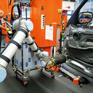 Bild 1: Gemeinsamer Arbeitsplatz: Im BMW-Werk in Spartanburg/USA fixiert der Roboter Isolierungsfolien an den Türinnenseiten.