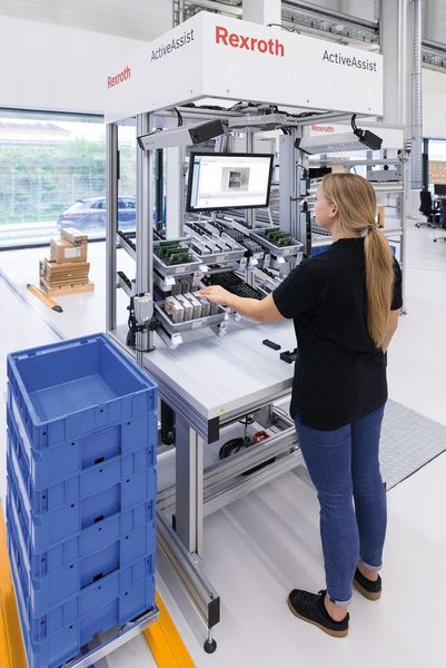 Die Vernetzung von manueller Arbeit und Softwarefunktionen zeigt sich ganz praktisch an intelligenten Arbeitsplätzen für die variantenreiche Fertigung. Die zu montierenden Werkstücke identifizieren sich per RFID und die Station ruft die entsprechenden Arbeitspläne aus einem übergeordneten System ab. Auf dieser Basis docken Anwender verschiedenste Assistenzsysteme an, die die Arbeitsanweisungen visualisieren und in der Wunschsprache des Mitarbeiters beschreiben. Montagestellen und entsprechende Anbauteile können mit Licht markiert und Arbeitsschritte direkt überprüft werden. Parallel zur aktuellen Montage erstellt die Arbeitsvorbereitung die Arbeitsabläufe für weitere Produkte und legt sie auf dem Server ab. (Bosch Rexroth)