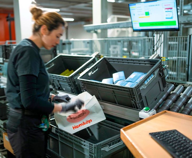 Die Kommissionierung der E-Commerce-Aufträge erfolgt in allen Temperaturbereichen an teilautomatisierten ergonomischen Arbeitsplätzen direkt in die Versandtasche. (Bild: Witron)
