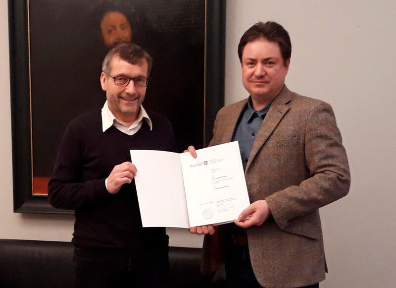 Prof. Walter Rosenthal, President of Friedrich Schiller University Jena, hands over the document of appointment to Prof. Tomáš Čižmár. (private)