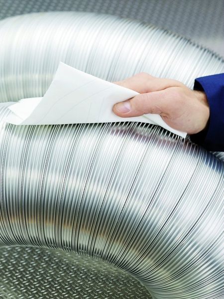 Bild 3: Der Mitarbeiter entfernt das Wasser, Öl oder Lösungsmittel mit einem aus dem Spender gezogenen Tuch und entsorgt es nach einmaligem Gebrauch. Gegen Metallspäne ist er bei mehrlagigen Papierqualitäten geschützt. Bilder: SCA Hygiene (Archiv: Vogel Business Media)