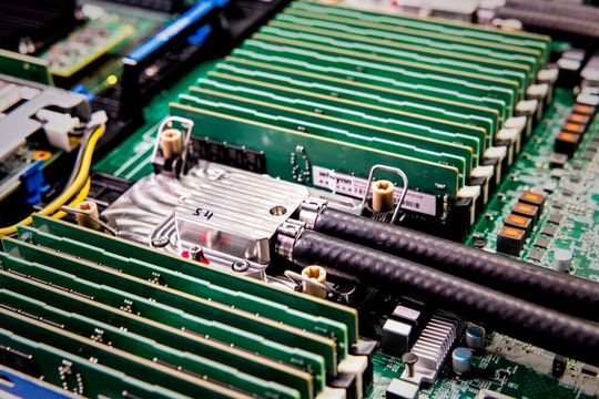 Eingehaust: Der Mikrofluidik-Chip von Microsoft besitzt angeschlossene Leitungen, damit das Kühlmittel im Chip zirkulieren kann.(Bild:  Dan DeLong/Microsoft)