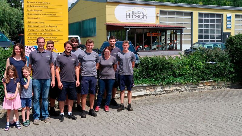 Inhaberfamilie (links) und Mitarbeiter von Auto Hirsch, im Hintergrund das Werkstattgebäude. Inhaberfamilie (links) und Mitarbeiter von Auto Hirsch, im Hintergrund das Werkstattgebäude.