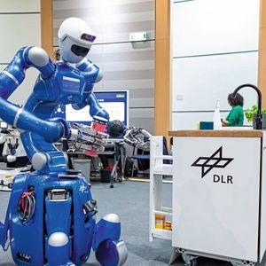 Der humanoide DLR-Roboter Rollin‘ Justin hat die Müslischachtel auf dem Tisch erkannt und stellt sie selbstständig wieder zurück an ihren Platz im Schrank. Seine nachgiebig geregelten Gelenke stellen sicher, dass er sicher und präzise mit seiner Umgebung interagiert. Wissensgestützte KI und moderne Lernverfahren ermöglichen Rollin‘ Justin dabei eine zuverlässige, autonome Aufgabenausführung.(Bild:  DLR (CC BY-NC-ND 3.0))